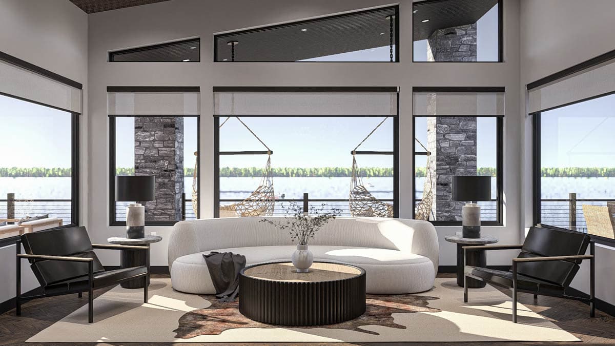 Interior rendering of a great room with a large curved sofa, modern chairs, a round coffee table, and panoramic windows overlooking a lake.