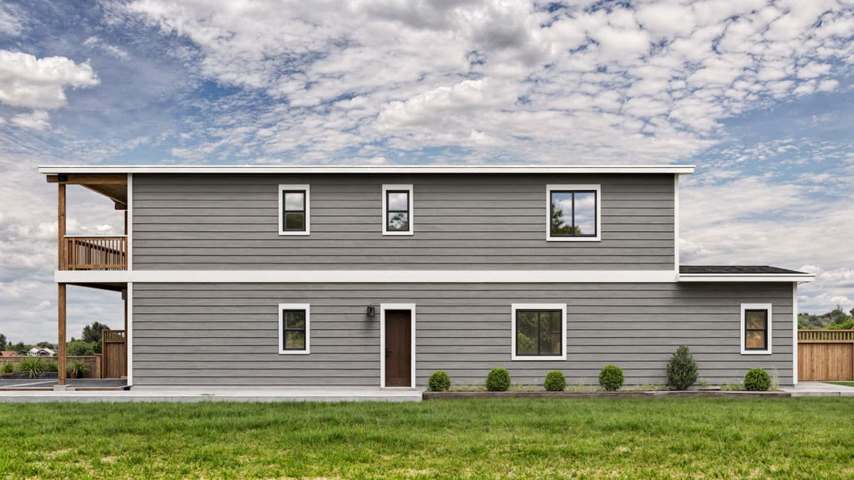 Two-story house plan exterior with horizontal siding, prominent second-story balcony, and multiple windows.