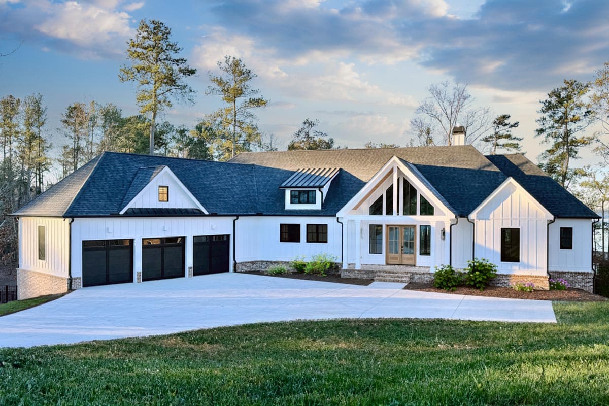 House plan exterior. Modern Farmhouse style with gabled roof, three-car garage, and front porch with exposed beams.
