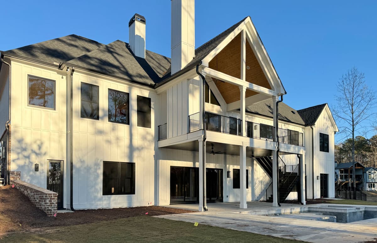 Modern Farmhouse house plan exterior with white board and batten siding, gabled roof, and multi-level balconies.