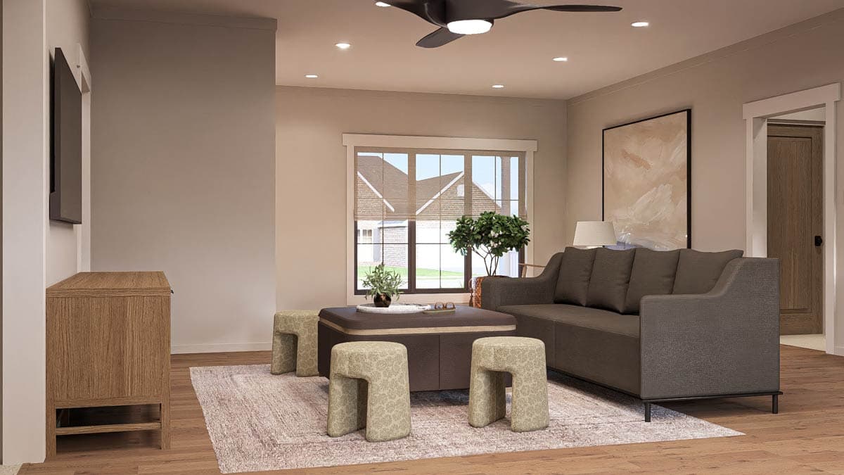 Living room with a sectional sofa, coffee table, ottomans, media console, and a large window overlooking houses.