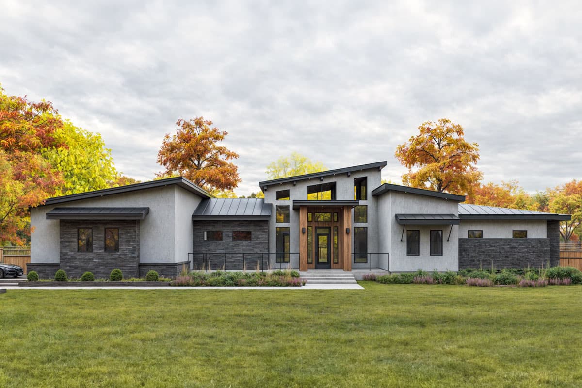 House plan exterior. Modern style, one-story home with a sloped roof, an asymmetrical facade, and a recessed entry with wood accents.