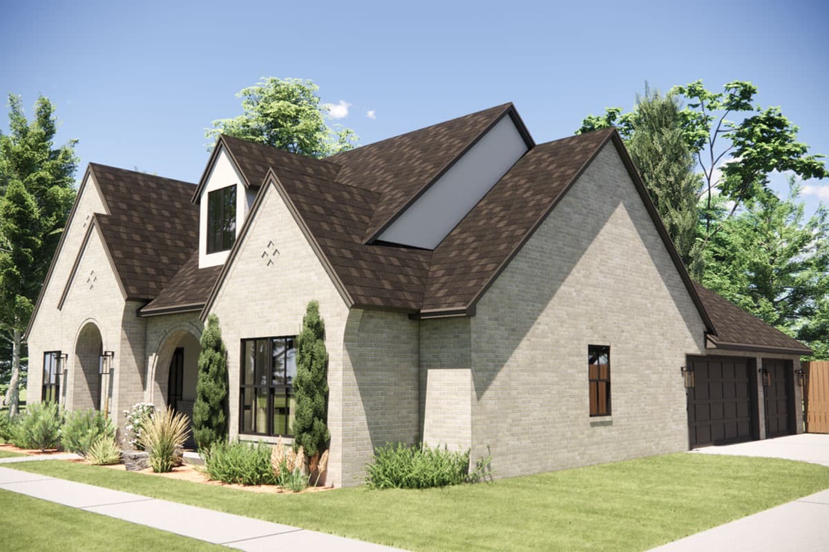 House plan exterior: light brick, gabled roof, dormer window, arched entry, and a two-car garage.