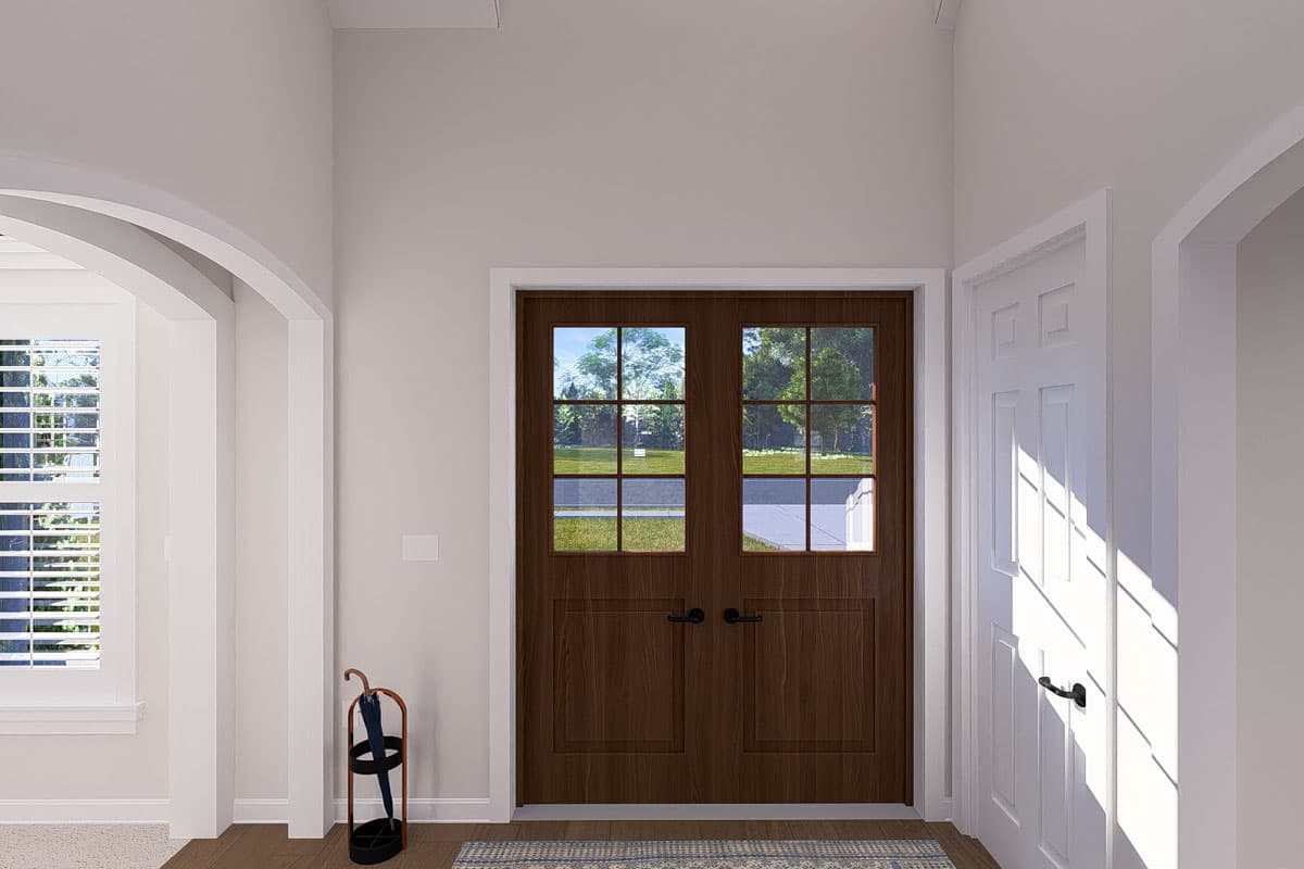 House plan interior view showing double entry doors with glass panes, arched entryway, and plantation shutters on window.