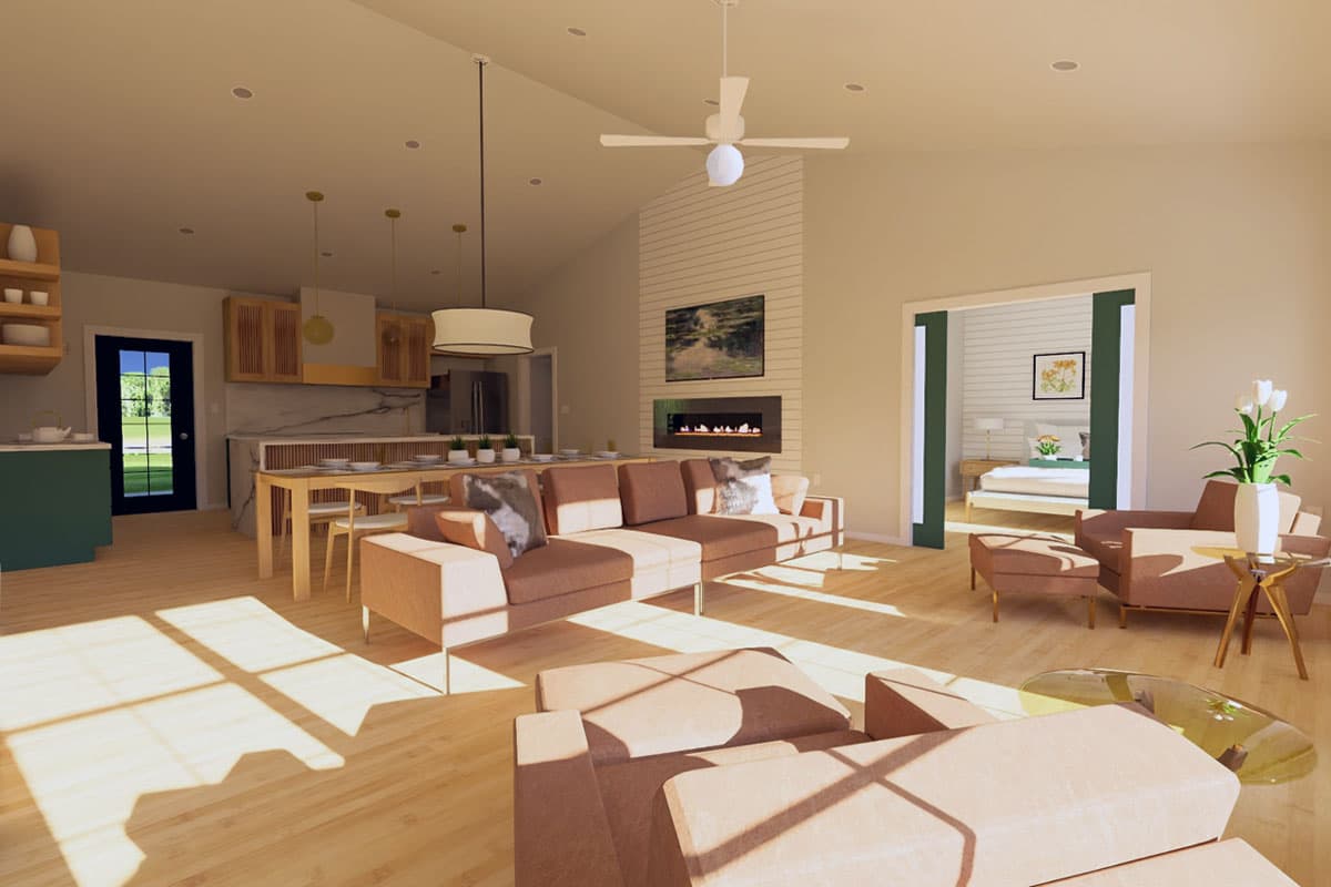 Interior view of open-concept living area with vaulted ceiling, modern fireplace, dining, and kitchen.