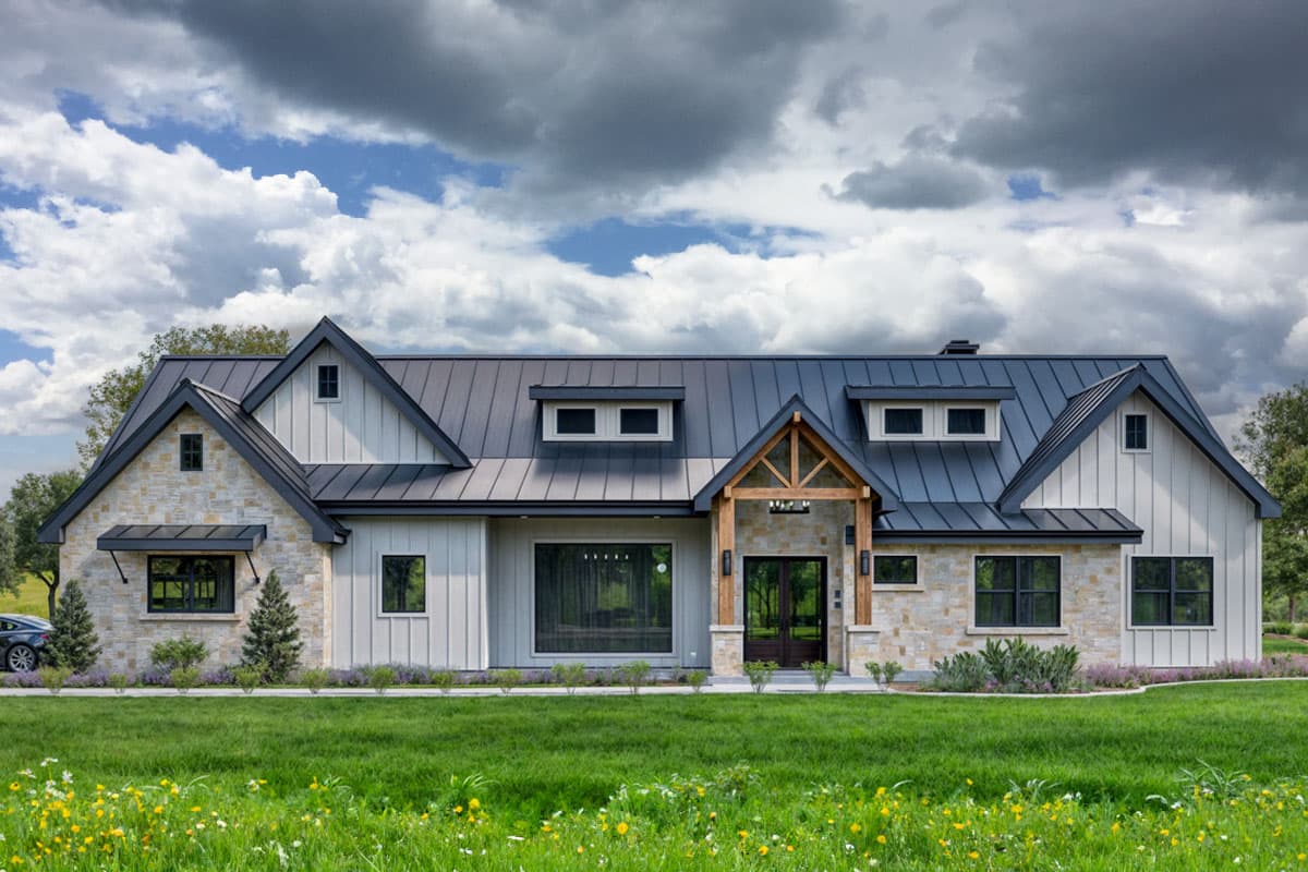 House plan exterior. Modern Farmhouse style with metal roof. Features include gables, dormers, and a covered front entry.