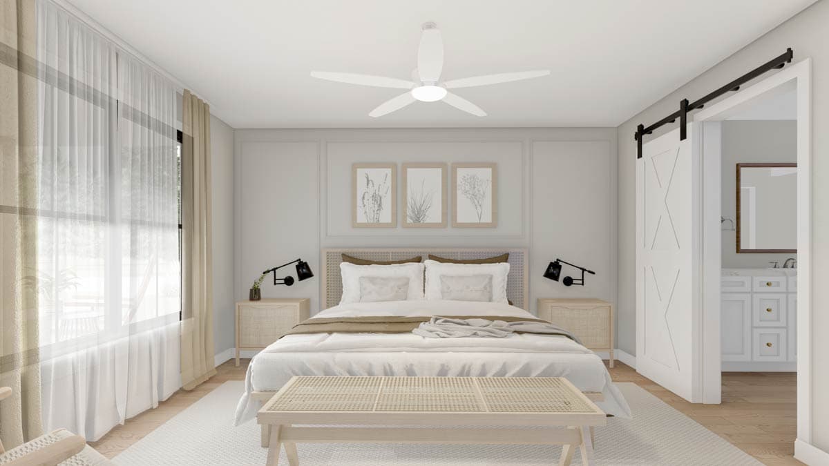 Modern bedroom with king bed, wall art, barn door to bathroom, and large window with sheer curtains.