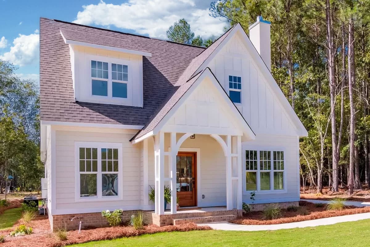 House plan exterior with Craftsman style, two stories, front porch with archway, gables, and dormers.