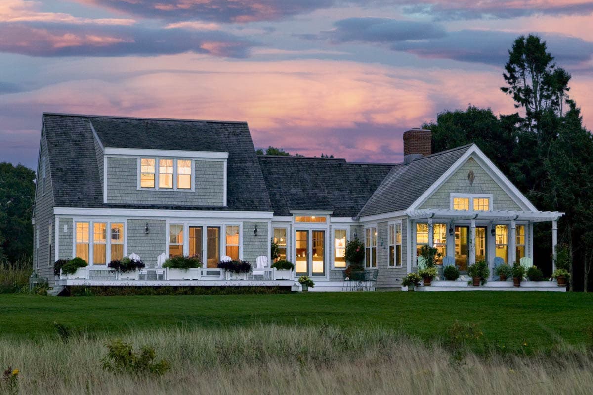 House plan exterior. Two-story, shingle-style house with dormers, gabled roof, and covered porch.