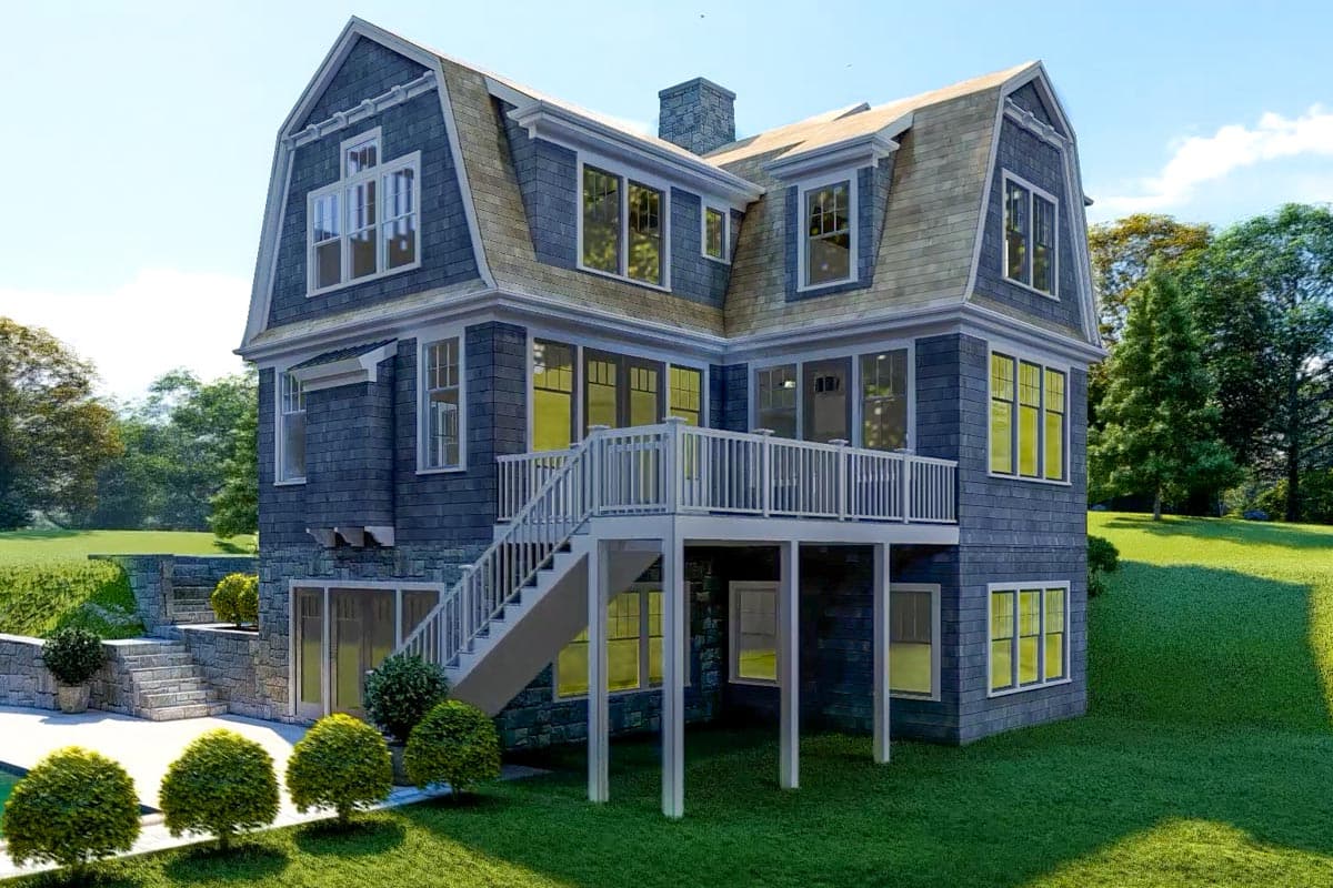 House plan exterior: Gambrel roof, shingled facade, elevated deck with stairs, dormers, and stone foundation elements.