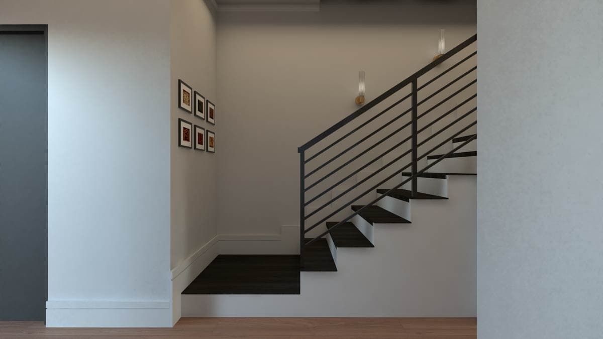 Interior view of a staircase with dark wood treads, white risers, and black metal railings. Six framed pictures hang on the wall.