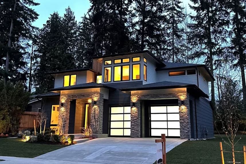 Modern two-story house plan exterior with stacked stone accents, multiple gables, and a three-car garage.