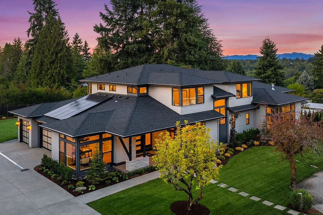 Modern house plan exterior with solar panels, covered entry, multiple gables, and large windows.