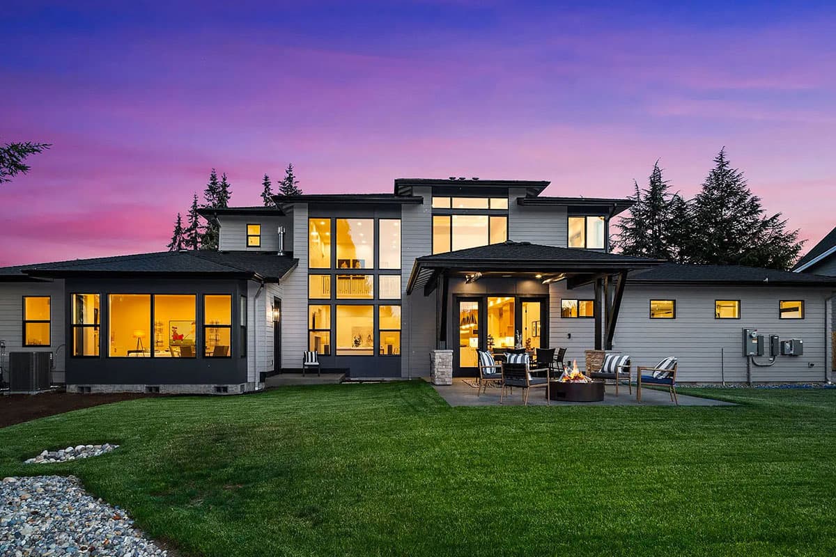 Modern two-story house plan exterior with extensive windows, covered patio, and flat rooflines.