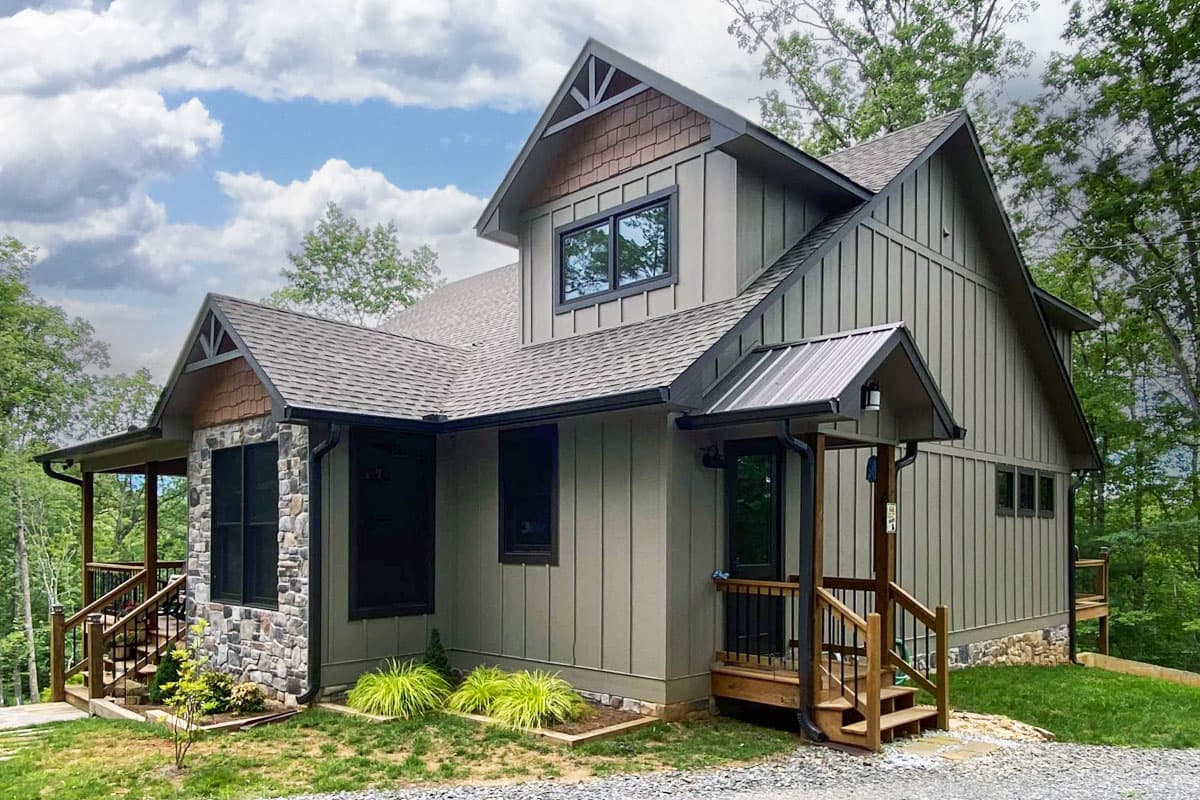 House plan exterior with Craftsman style. Features include a stone facade, gabled rooflines, and a covered porch. Two stories.