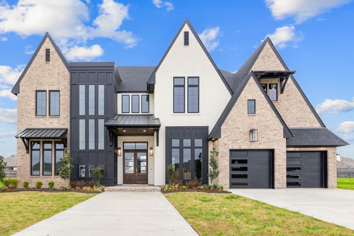 House plan exterior with two stories. Features include brick and stucco facade, multiple gables, and a three-car garage with modern garage doors.