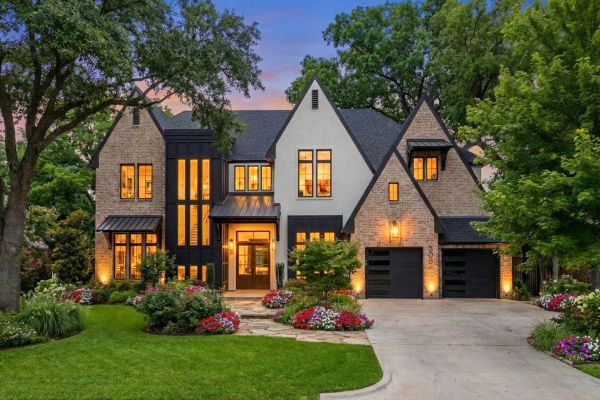 Modern Farmhouse house plan exterior with brick and white stucco, gables, prominent front door, and attached three-car garage.
