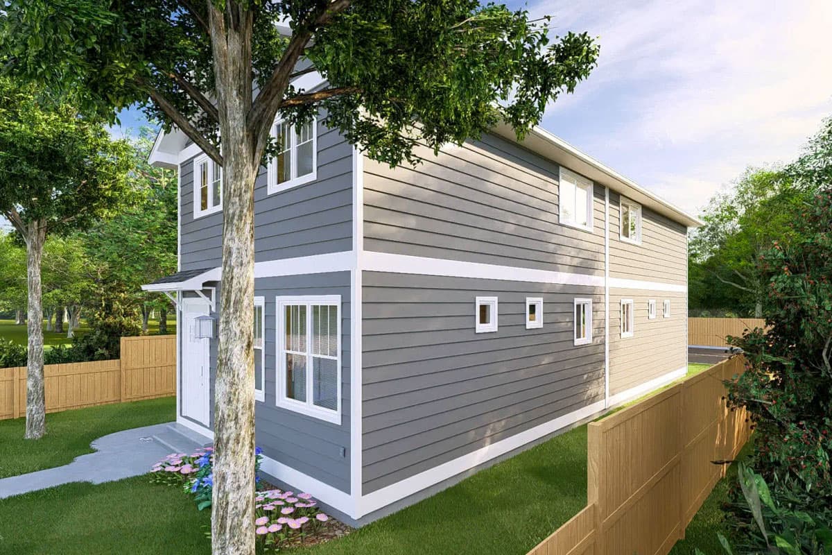 Two-story house plan exterior with gray lap siding, white trim, multi-paned windows, and a covered front entry.