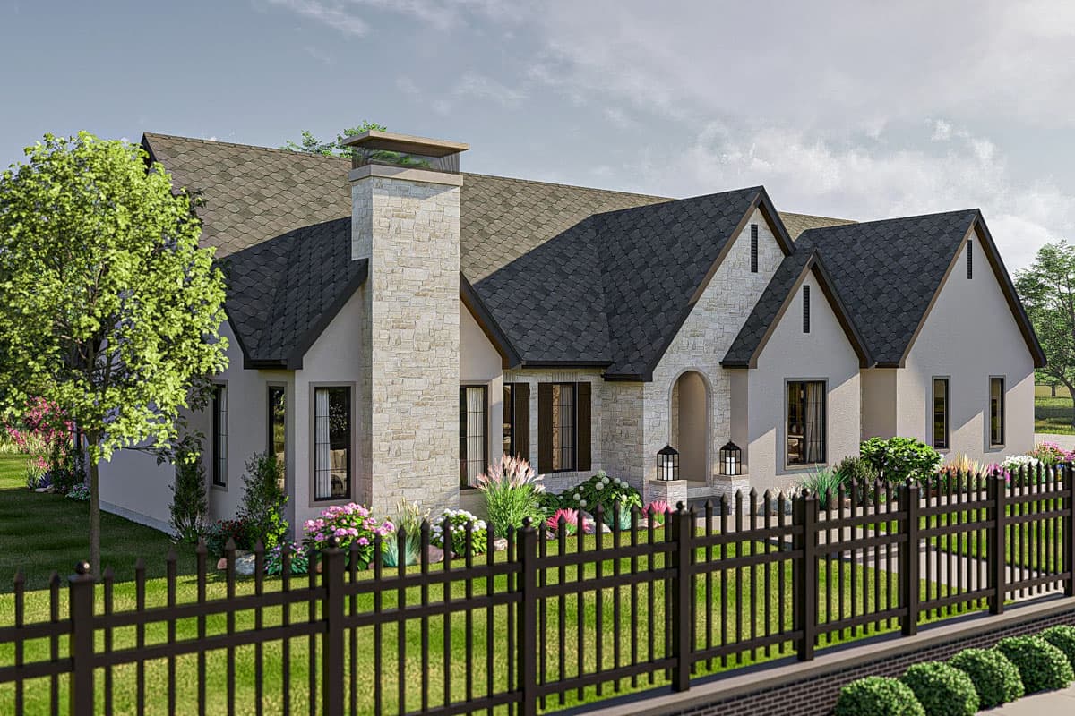 House plan exterior with stone chimney, arched entryway, gables, and a dark metal fence.
