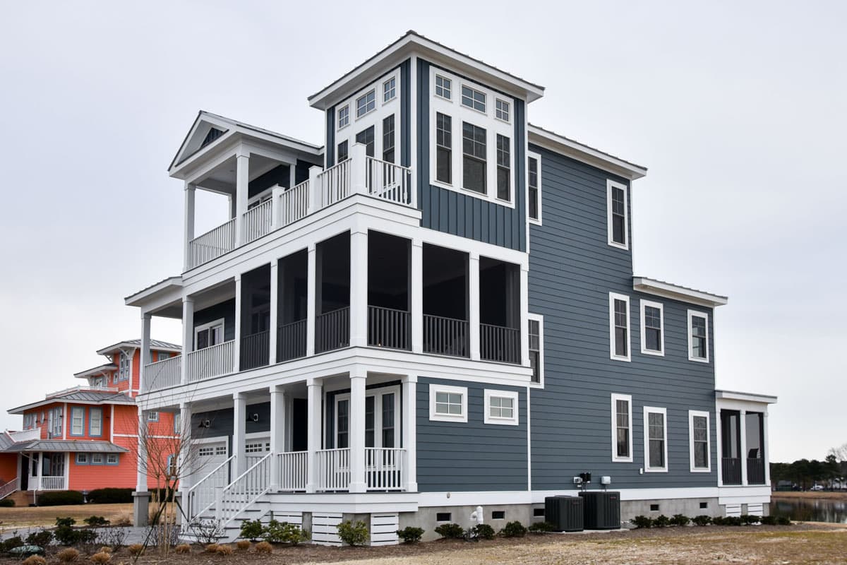 House plan exterior shows a multi-story coastal home with multiple screened porches, balconies, and a tower section.