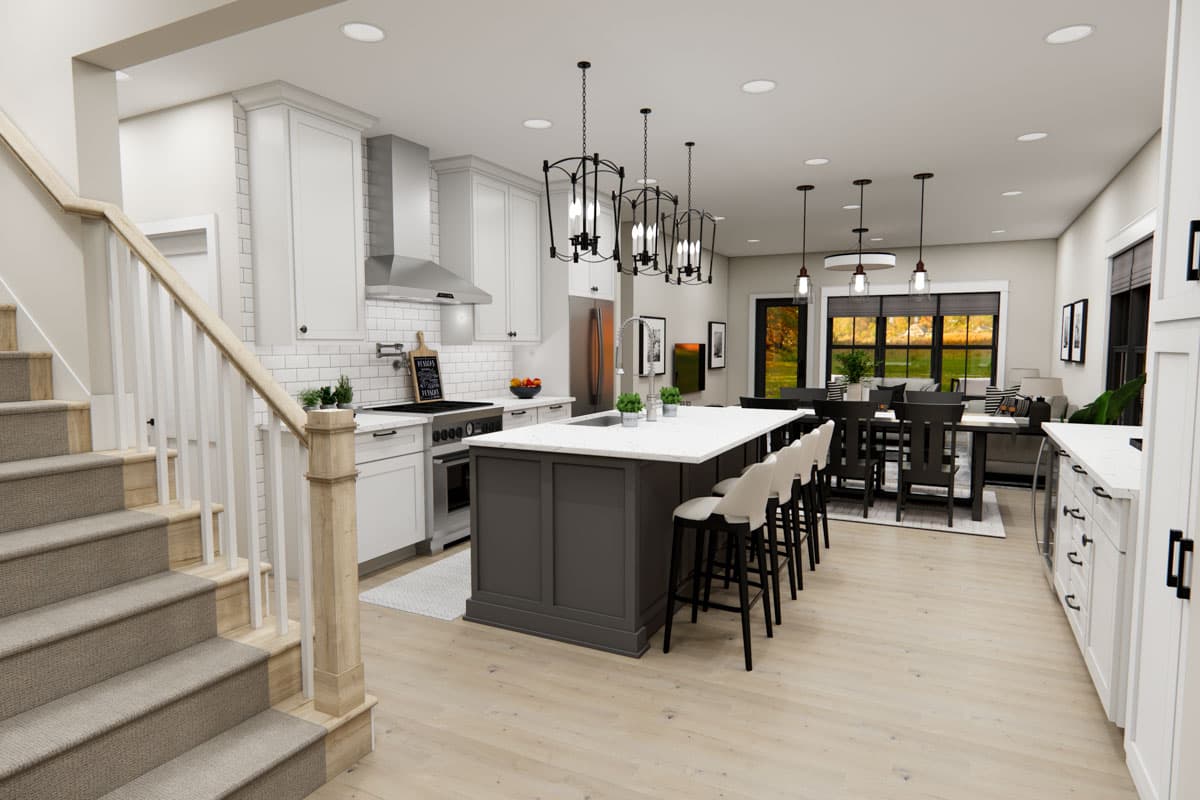 Kitchen with island, stainless steel appliances, white cabinetry, subway tile backsplash, and open dining area.