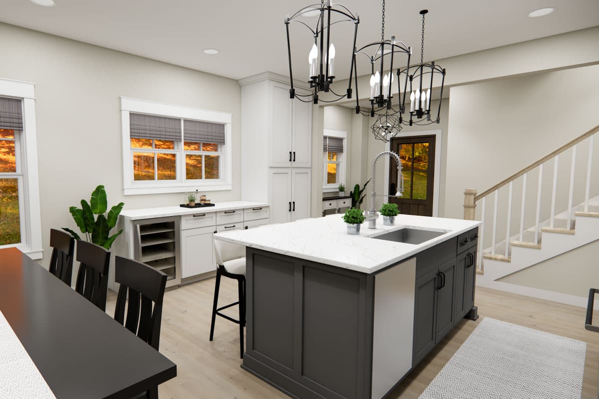 Kitchen with island sink, bar seating, white cabinets, a dining area, and staircase.
