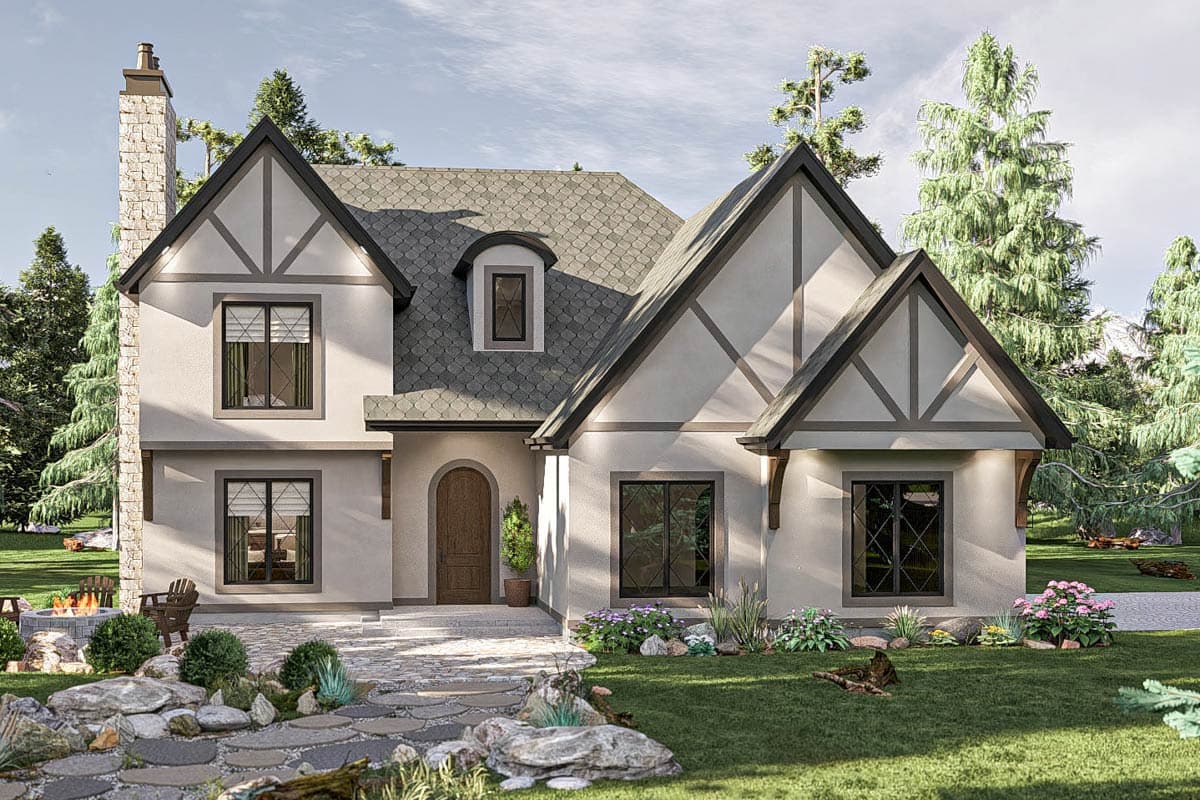 Tudor house plan exterior. Two-story home with multiple gables, arched entry, and a prominent chimney. Features include decorative half-timbering.