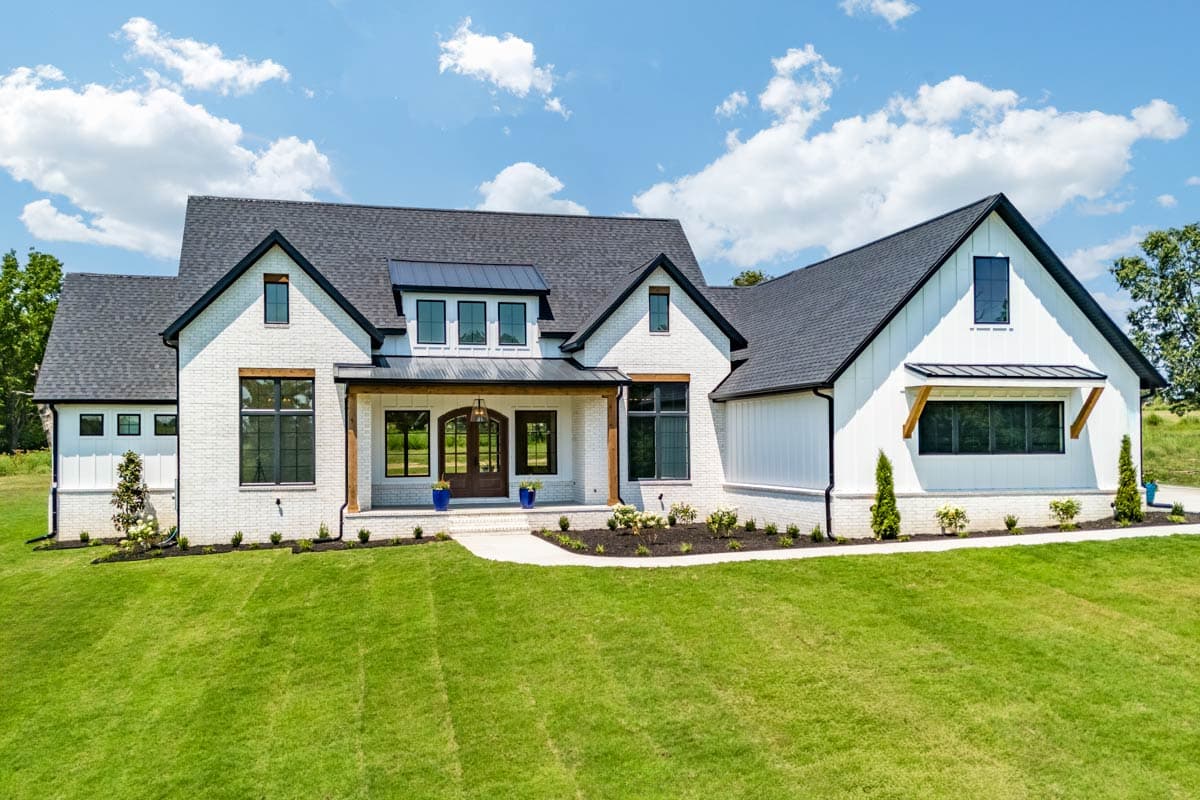 House plan exterior. Two-story Modern Farmhouse with gabled roof, covered porch, and dormers. Features brick and board and batten siding.