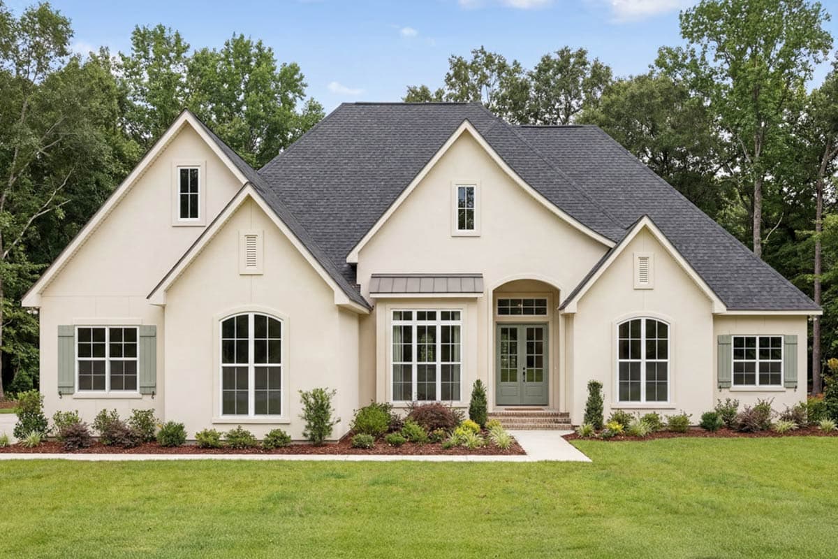 House plan exterior with stucco siding, gabled roof, and arched windows. Features include a front porch and dormers.