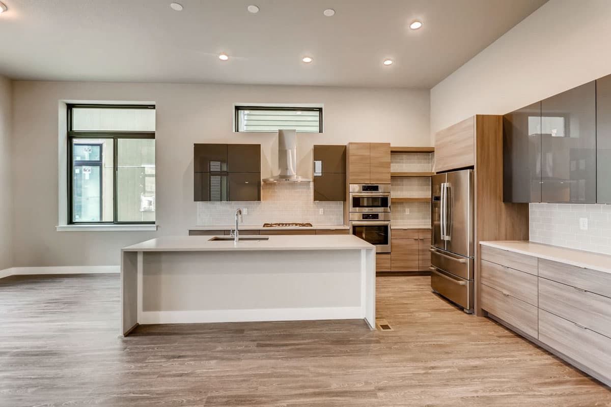 Modern kitchen with large island, stainless steel appliances, gas range, and ample cabinet storage.