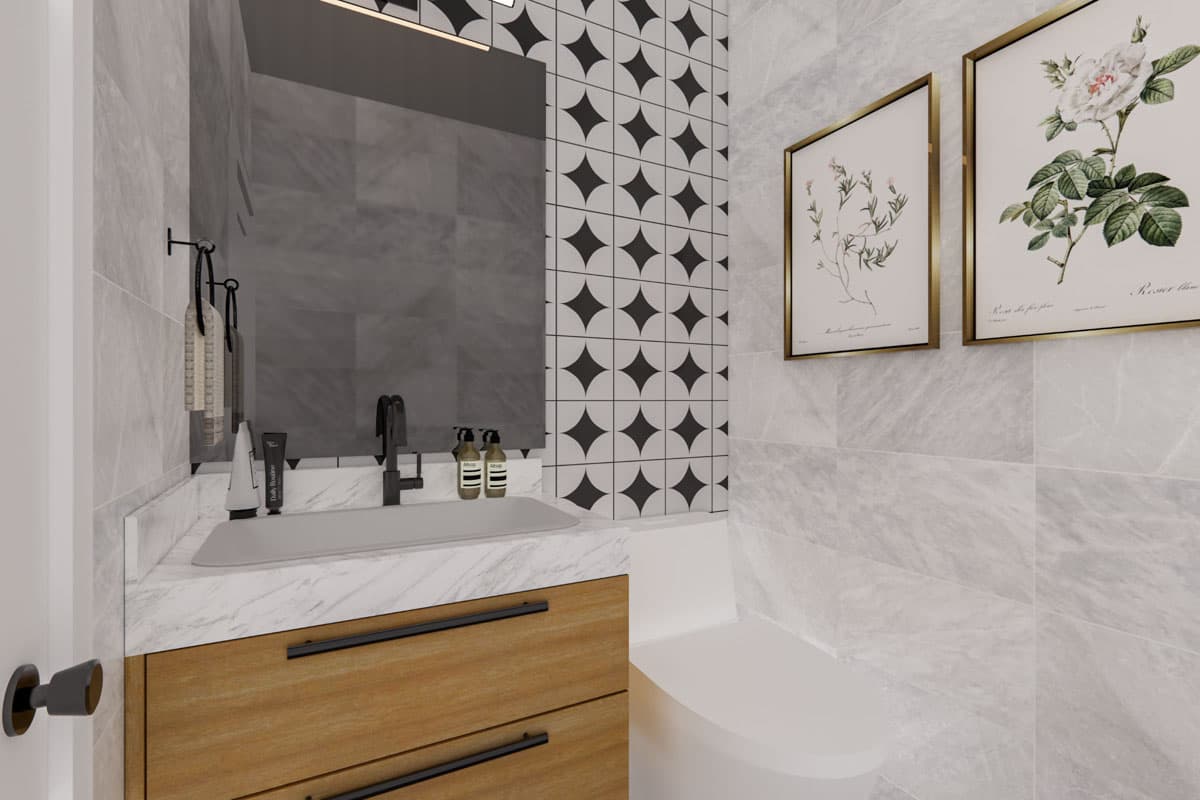 Bathroom vanity with marble countertop, wood cabinets, and geometric tile backsplash. Framed botanical prints above toilet.