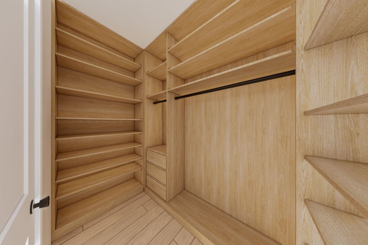 Walk-in closet with built-in wood shelving, drawers, and a hanging rod.
