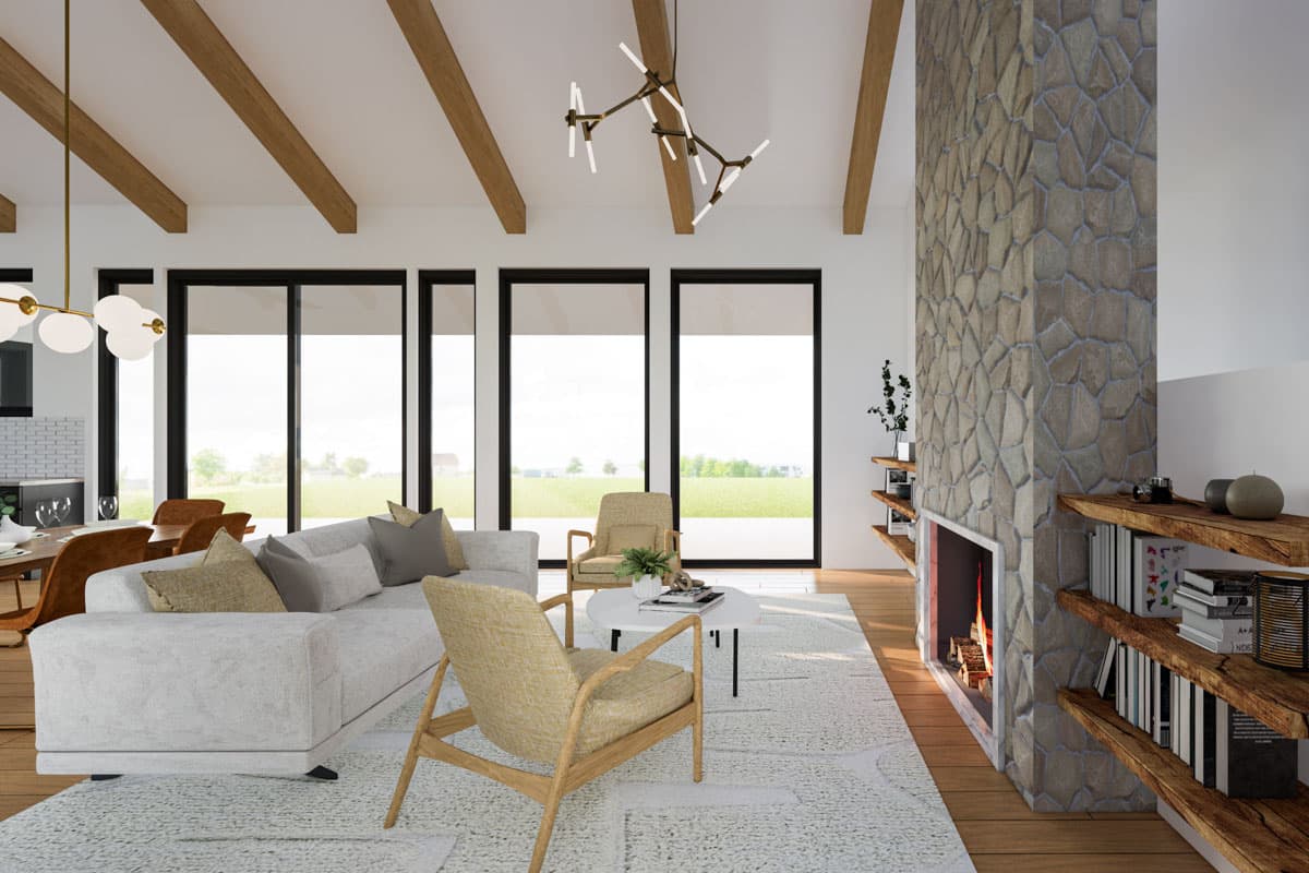 Living room with vaulted ceiling, exposed beams, stone fireplace, and large windows.