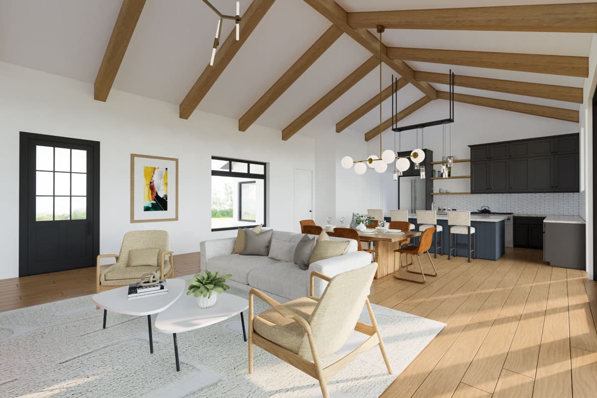 Open concept living area with vaulted beam ceiling, sectional sofa, dining table, kitchen island with bar stools, and black french doors.