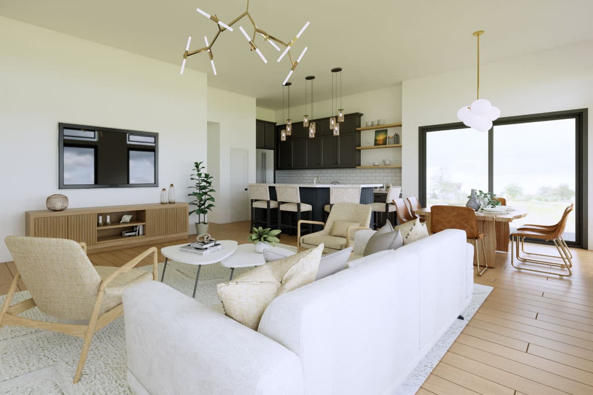 Open-concept living space with a sectional sofa, accent chairs, kitchen island with seating, and dining area.