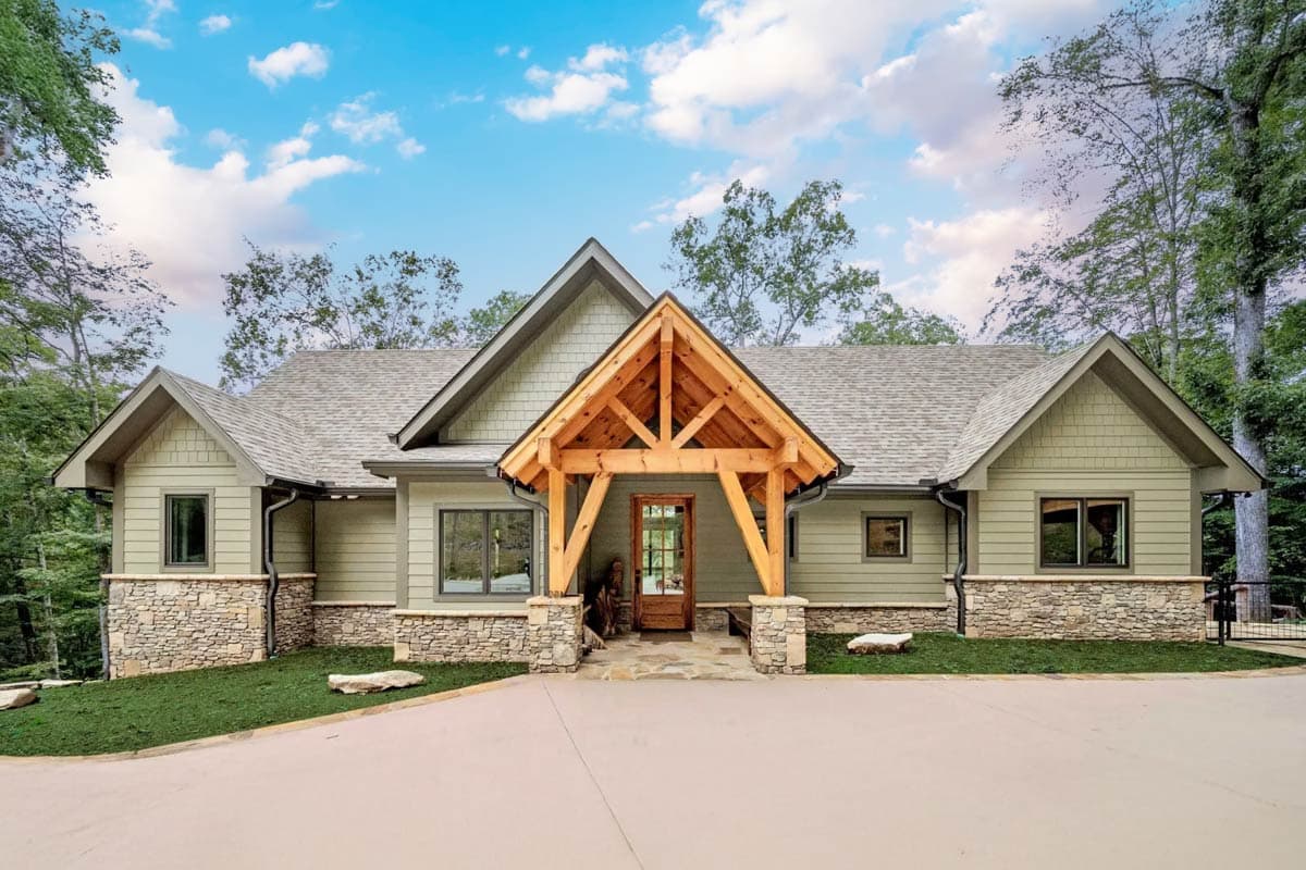 House plan exterior with Craftsman style. Features include a timber-framed entry porch, stone accents, and multiple gables.