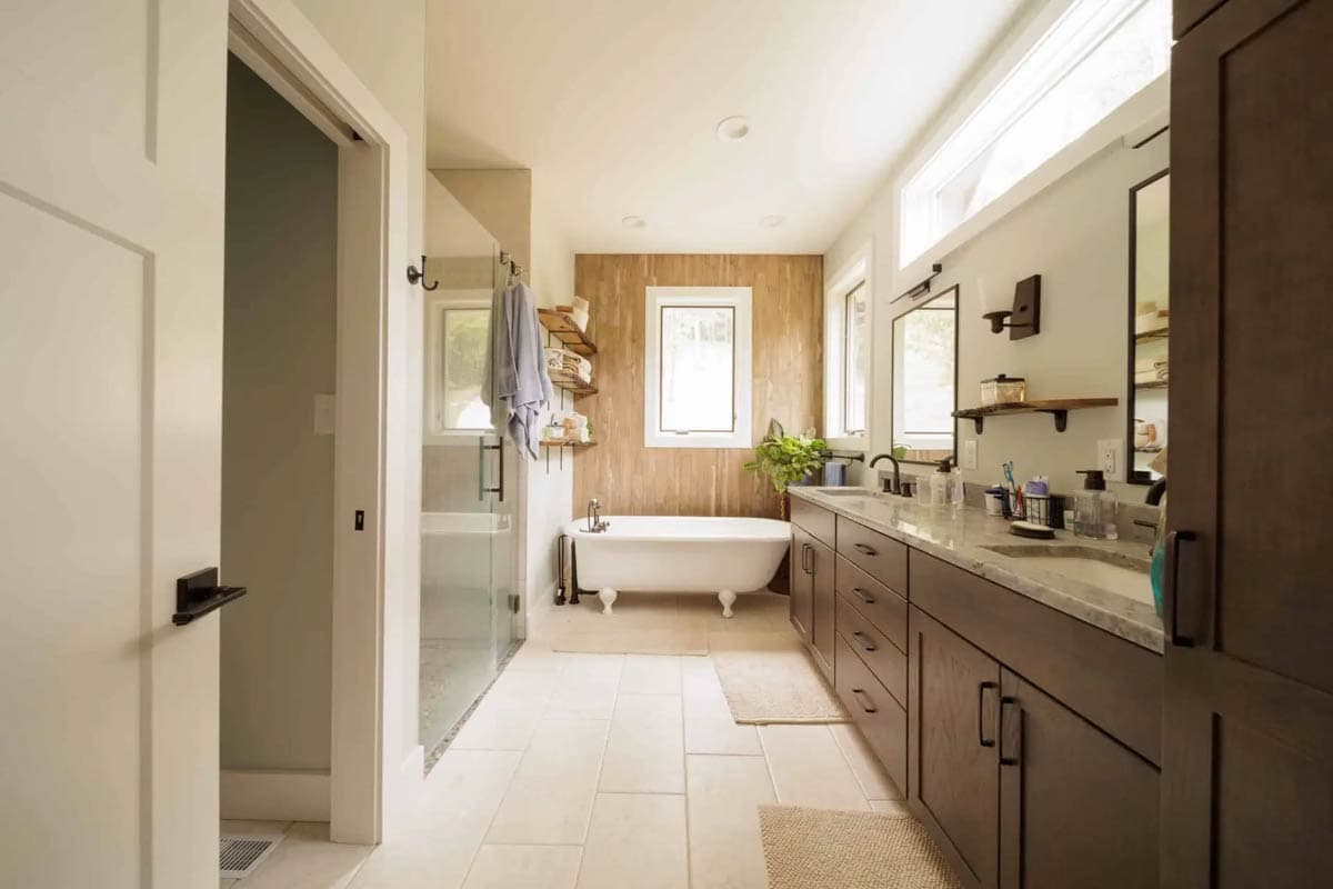 Spacious bathroom with freestanding tub, glass shower, and double vanity with dark wood cabinets.