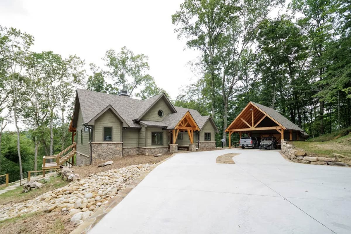 House plan exterior: Two-story Modern Farmhouse with stone accents, prominent gables, and a detached timber-frame carport.