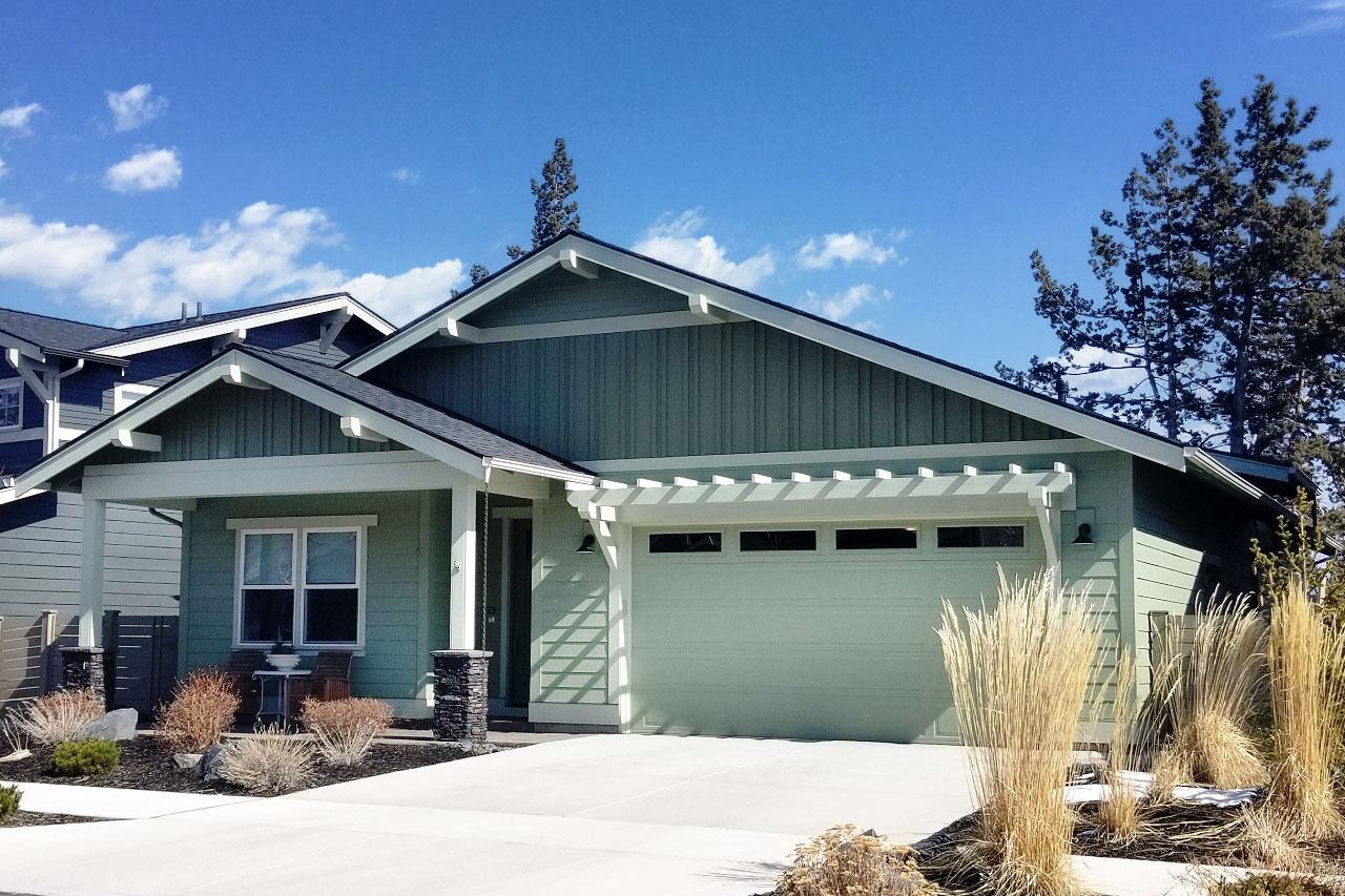 House plan exterior with Craftsman style. Features include a front porch, gables, and a pergola above the garage door.