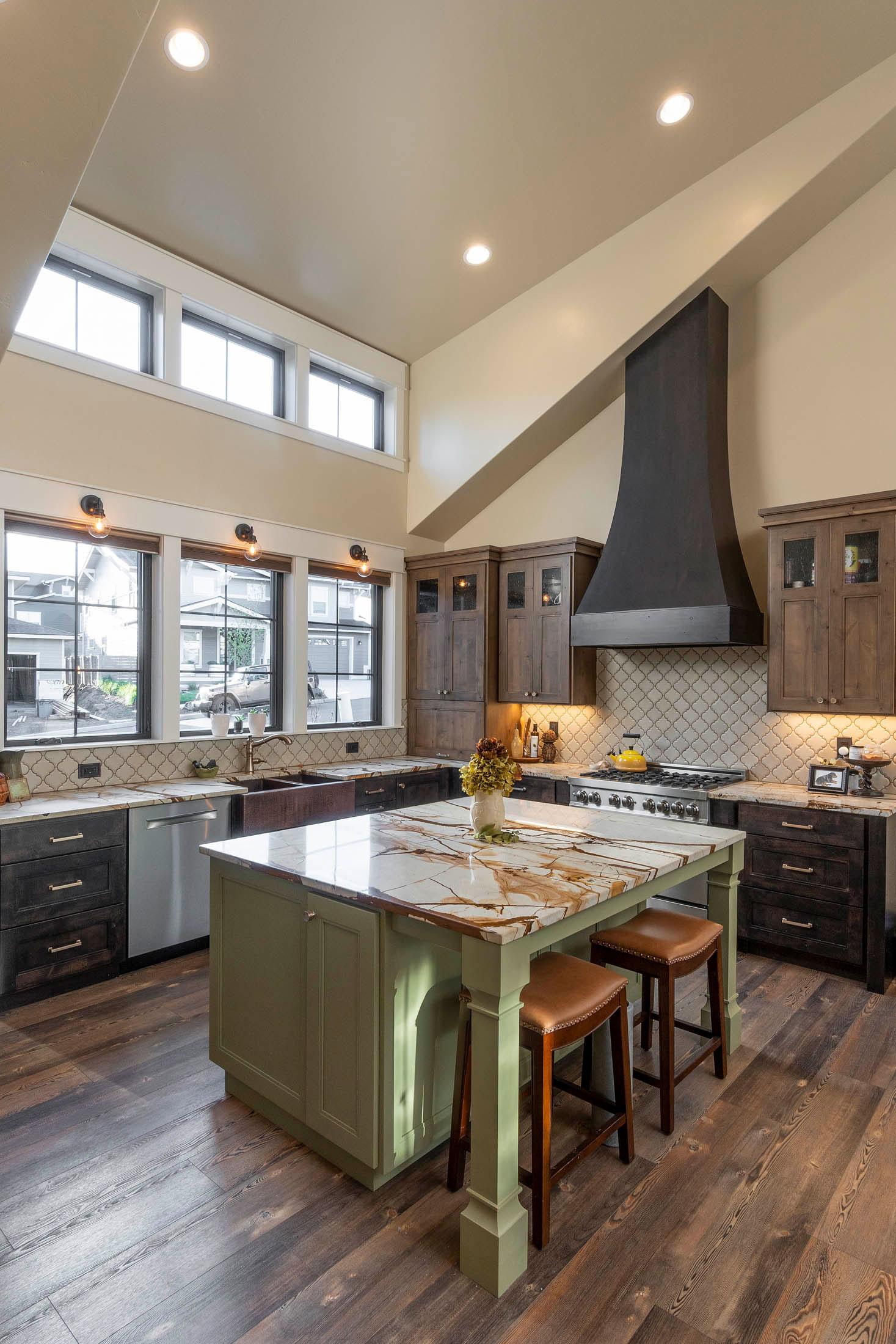 Kitchen with vaulted ceiling, large island with seating, dark wood cabinetry, and stainless steel appliances.