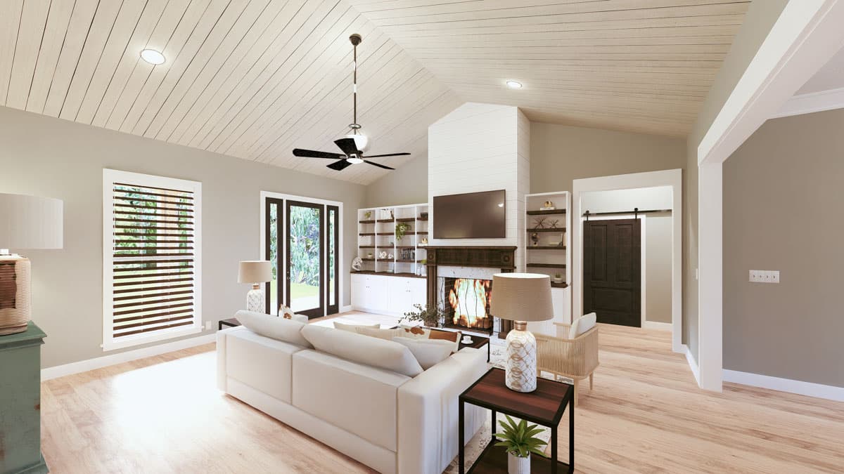 Great room with vaulted shiplap ceiling, fireplace, built-in shelving, and barn door entry.