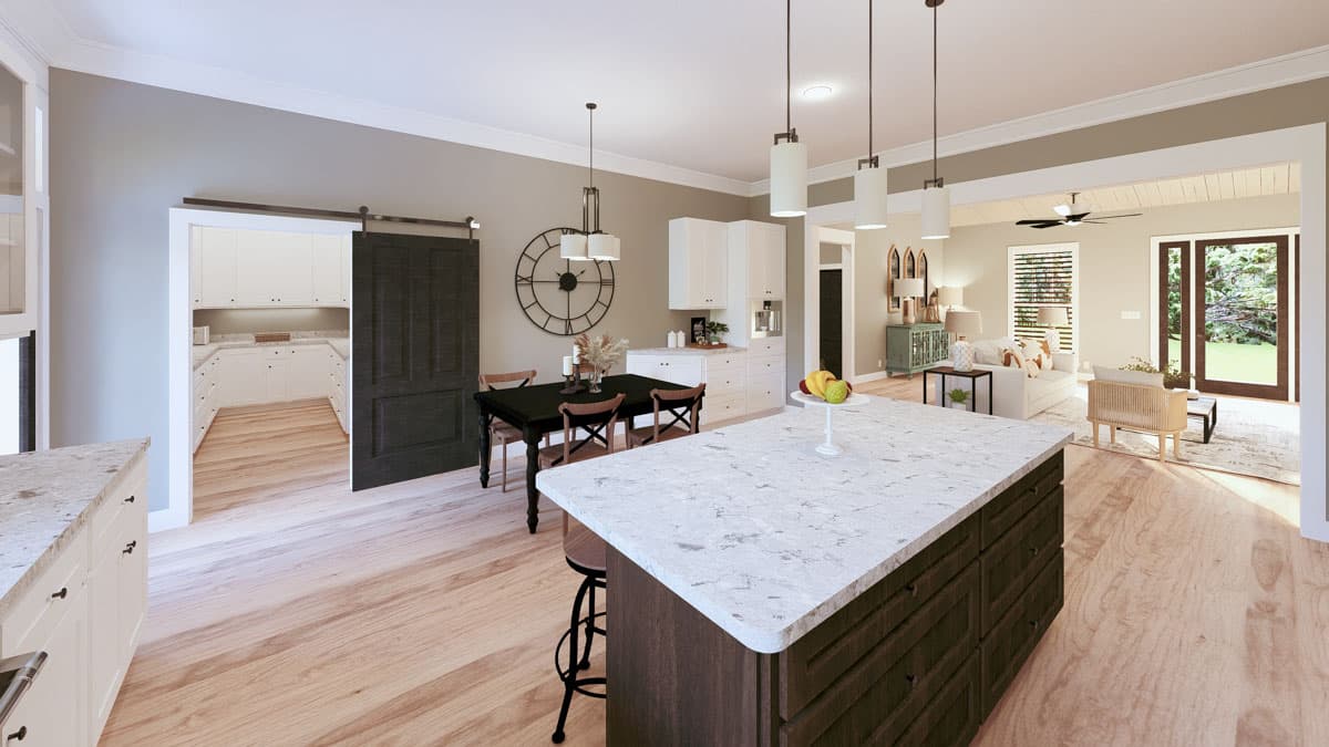 Open-concept kitchen with island, dining area, and pantry, flowing into a living room with large doors to yard.