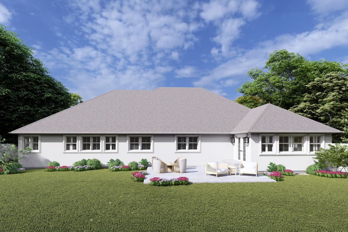 House plan exterior: Single-story residence with a hip roof, multiple grid-pane windows, and a patio area with outdoor furniture.