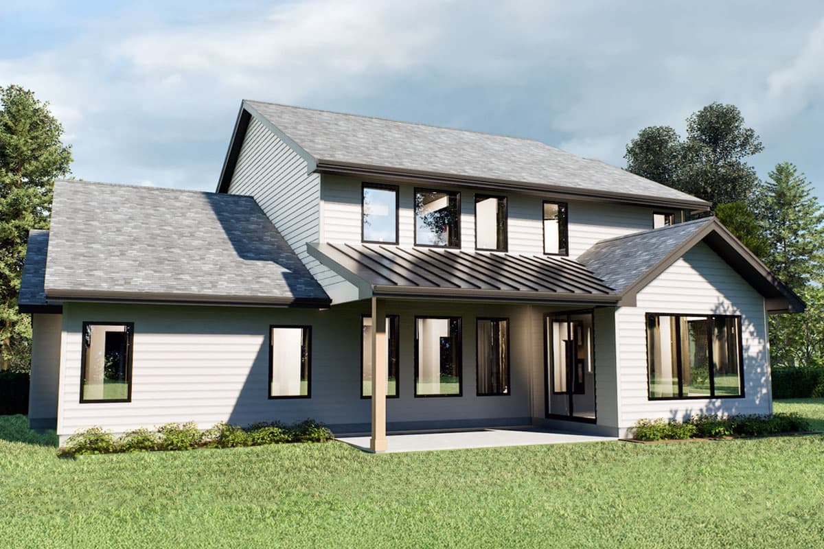 A modern two-story house with a gray roof and white siding. Large windows are featured throughout the exterior, and it is surrounded by a green lawn.