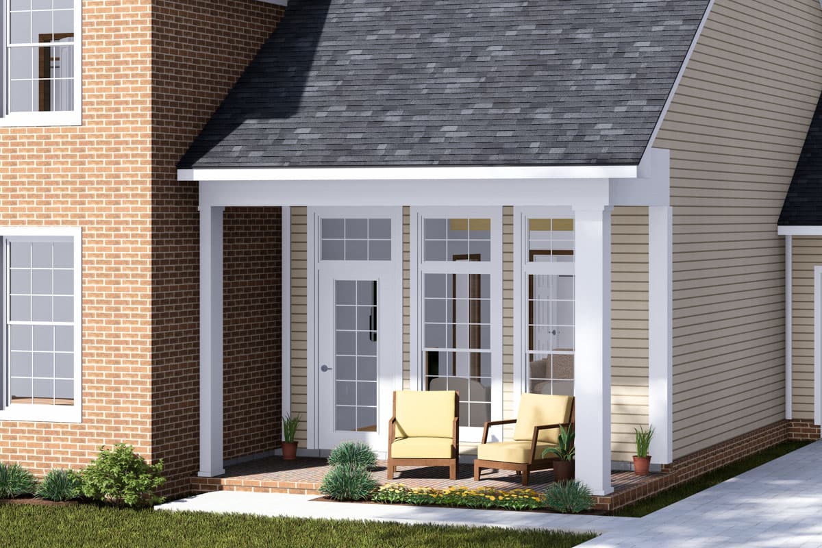 House plan exterior with brick and vinyl siding, multiple windows, and a covered porch with two chairs.