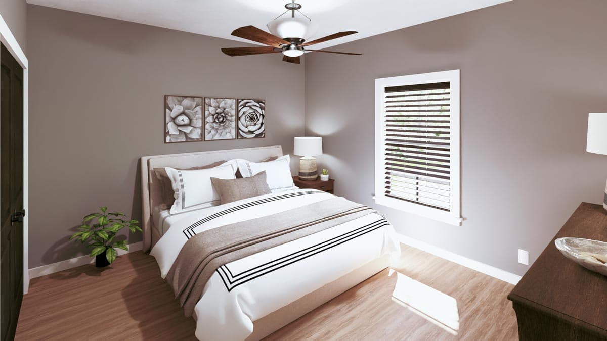 A modern bedroom with a large bed, featuring a white comforter with black stripes. A ceiling fan, artwork, and a window are also visible.