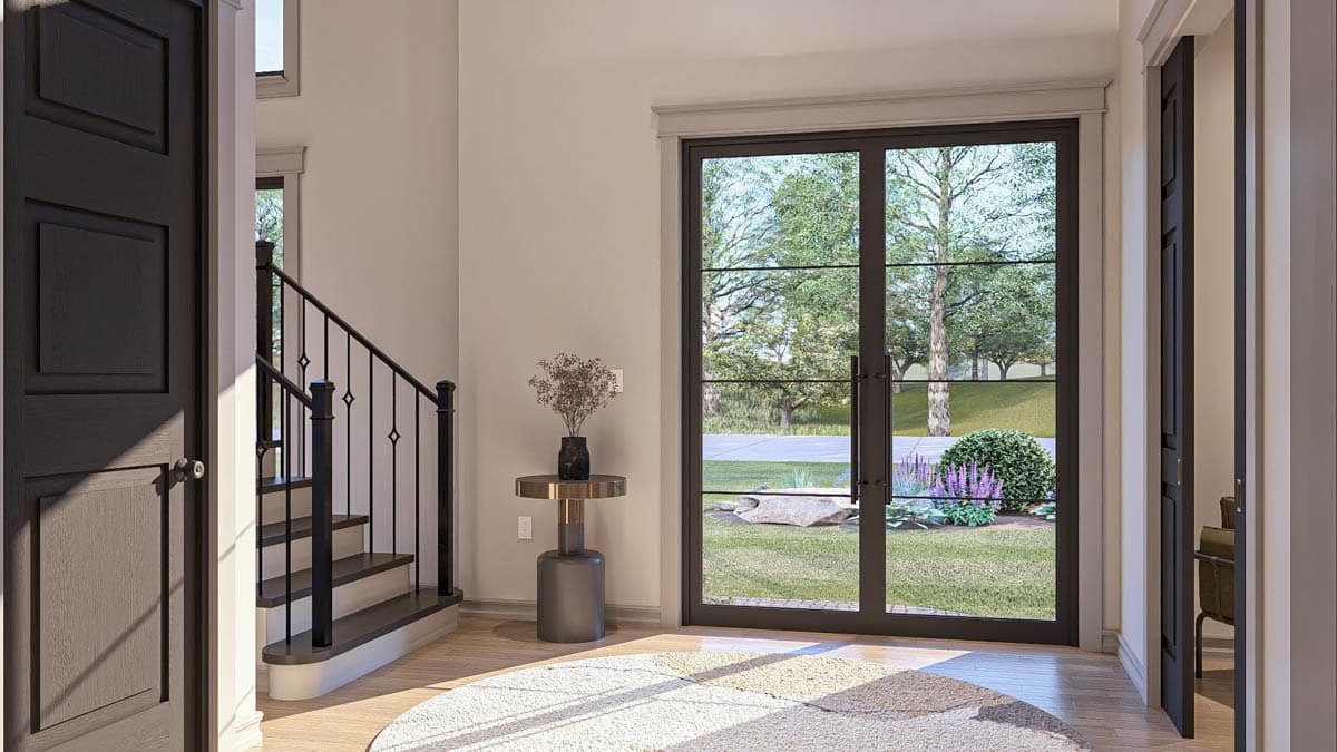 Interior view showing a staircase, dark panel door, and double glass doors opening to a backyard garden.