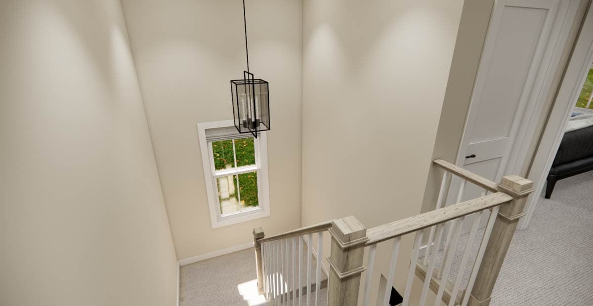Interior view of a house staircase with a window, a contemporary lantern light fixture, and carpeted stairs.