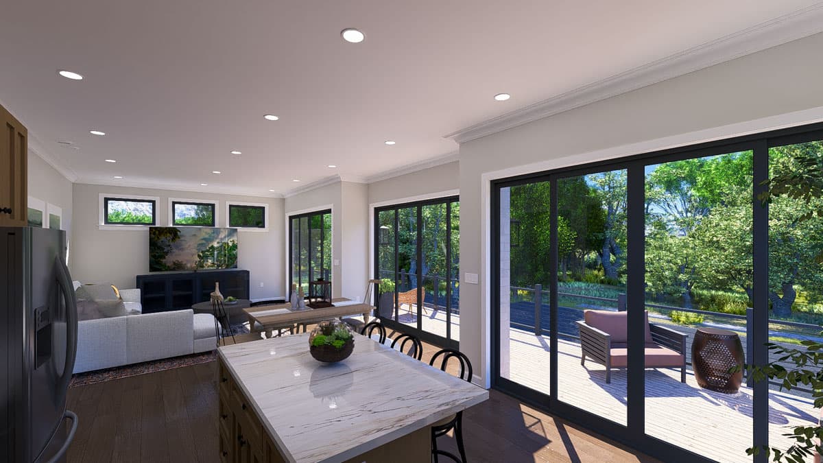 Open concept living area with kitchen island, dining table, and large sliding glass doors leading to a deck.