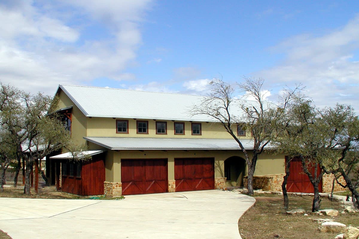 House plan exterior: Two-story modern farmhouse with metal roof, multiple gables, and three-car garage.